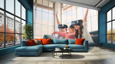 Happy asian family  playing video games with VR Headset and rise up hands, with their daughter down syndrome child in living room, Activity happy family lifestyle virtual reality goggles concept. Wall mural