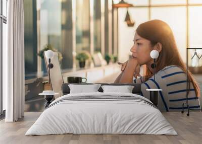 Young asia woman working on a laptop at home office in morning time, Selective focus. Wall mural