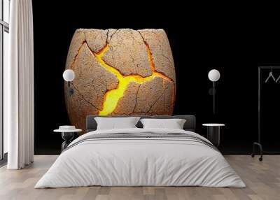 Cracked stone vase with glowing interior on black background. Wall mural