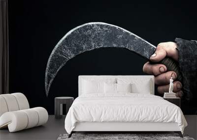 Hand holding a vintage curved scythe against a dark background. Wall mural