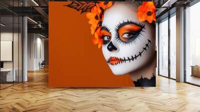 Woman with sugar skull makeup and flowers, orange background. Wall mural