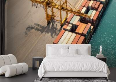 Aerial view of a cargo ship docked at the port, surrounded by colorful shipping containers and a large crane for loading. Wall mural