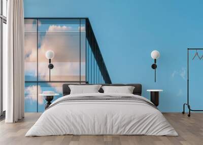 Modern glass building reflecting clouds against a bright blue sky, showcasing contemporary architecture and a serene urban landscape. Wall mural