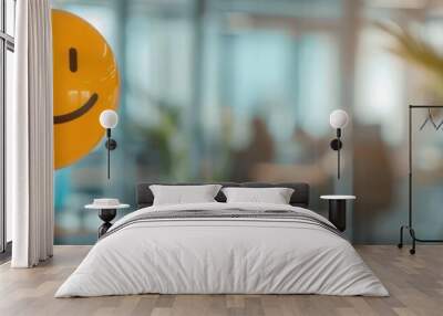 Orange smiley face balloon in a modern office space, symbolizing happiness and positivity at work. Wall mural