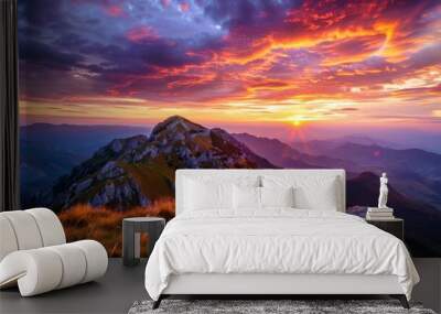 A dramatic sunset view of a mountain peak with a colorful sky Wall mural