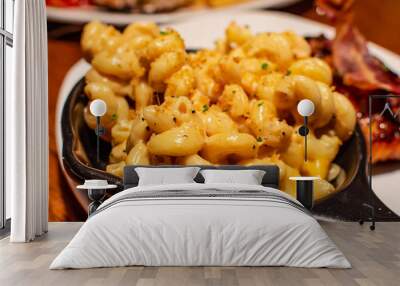 Macaroni and cheese also called mac and cheese or mac n cheese served in black small pan. Close up. Wall mural