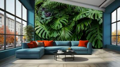 Green tropical leaves of Monstera, fern, and palm fronds the rainforest foliage plant bush floral arrangement on dark background, natural leaf texture nature background. Wall mural