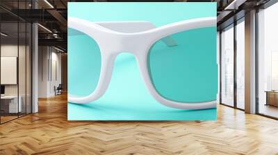 Stylish white sunglasses with teal lenses displayed against a vibrant blue background Wall mural