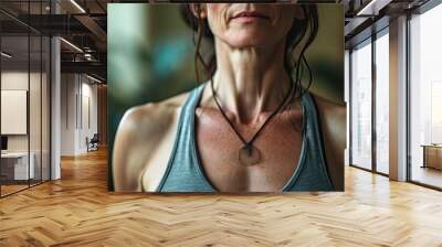 A woman's neck, highlighted by the muscles and skin of her human face, is framed by a sleeveless shirt as she stares confidently ahead, radiating strength and vitality Wall mural