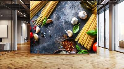 An array of classic Italian ingredients featuring raw spaghetti, vine tomatoes, fresh basil, whole garlic cloves, and olive oil bottles arranged on a dark textured surface. Wall mural