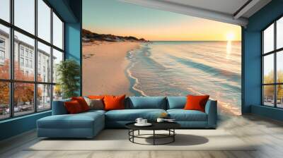 Golden sunset illuminating sandy beach with gentle waves crashing on shore Wall mural