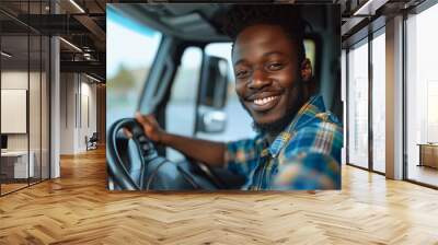 In this image, a happy man wearing casual attire is captured driving a vehicle outdoors, his beaming smile reflecting a sense of freedom and enjoyment. Wall mural