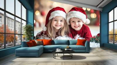 This joyful image features two smiling children wearing Santa hats in front of glowing Christmas lights, capturing holiday cheer and warmth in a cozy setting. Wall mural