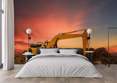 Home concept and Excavator digging the soil In the construction site on orange sky background Wall mural