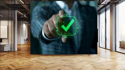 Businessman touching a green check mark icon on a virtual screen with a hologram effect, digital technology concept for success and quality in business Wall mural