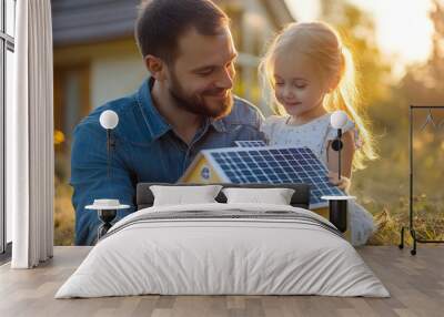 Little girl with her dad holding paper model of house with solar panels, explaining how it works.Alternative energy, saving resources and sustainable life concept. Wall mural