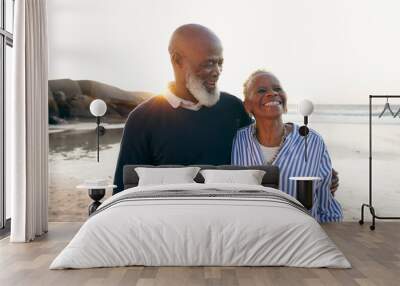 Senior couple, smile and hug on beach, love and bonding on vacation, holiday and trip to ocean. Happy black people, embrace and support or trust, commitment and connection in marriage or retirement Wall mural