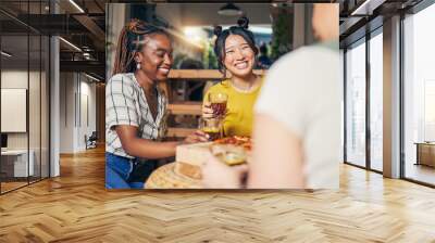 Friends, conversation and women with food in home for relaxing, bonding and lunch together. Friendship, happy and group of people with drinks laughing for relationship, visit and chat in living room Wall mural