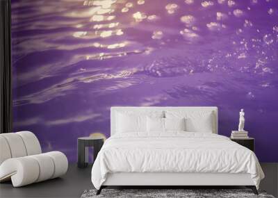 defocus blurred transparent purple colored clear calm water surface texture with splash bubble shining purple water ripple background surface of water in swimming pool purple bubble water shine Wall mural