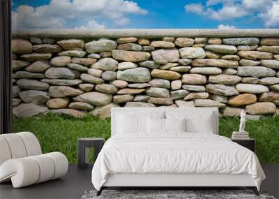 fence real stone wall surface with cement on green grass field Wall mural