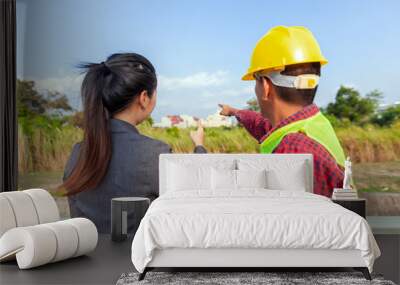 Businesswoman and foreman talking together. Engineer and manager teamwork and checking at site construction . Wall mural