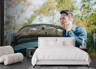 young man calling,  texting for car service on roadside assistance after broken car. Car broken, car breakdown concept. Wall mural