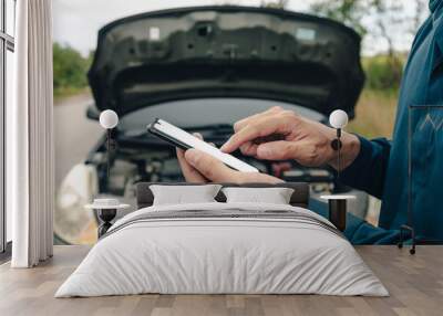 young man calling,  texting for car service on roadside assistance after broken car. Car broken, car breakdown concept. Wall mural