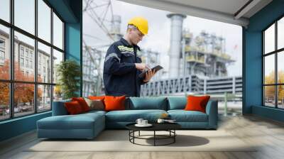 Petroleum engineer working with tablet  at oil refinery site Wall mural