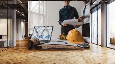 Civil engineer teams meeting working together wear worker helmets hardhat on construction site in modern city. Foreman industry project manager engineer teamwork. Asian industry professional team. Wall mural