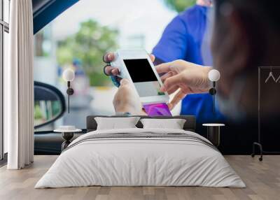 Gas station worker swipe mockup credit card via payment terminal after giving a price quote to the customer sitting in the car. Wall mural