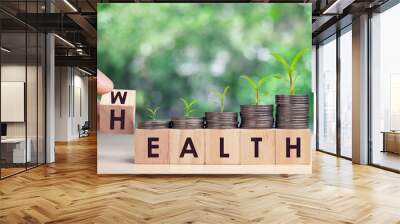 Hand flip wooden cube with word wealth to health with coins stack step up growing growth value. Investment in life insurance and healthcare concept Wall mural