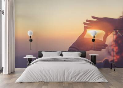 The woman making frame round the sun with her hands in sunrise,copy space,warm retro tone.  Wall mural