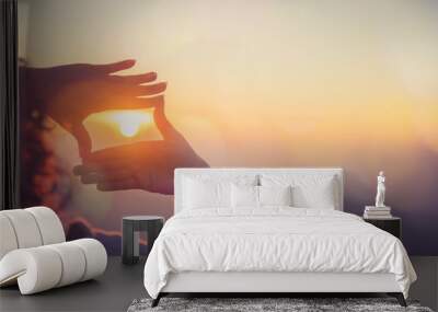 The woman making frame round the sun with her hands in sunrise,Future planning idea concept. Wall mural