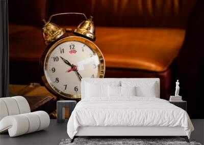 Vintage brass alarm clock on table. Wall mural