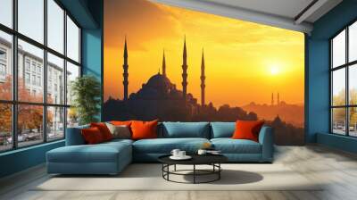 A mosque silhouetted against a golden sunrise, with the minarets towering over the peaceful Wall mural