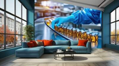 Scientist in a pharmaceutical production facility, wearing sterile gloves, inspecting vials Wall mural