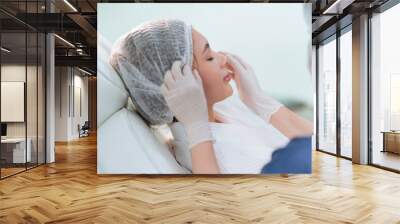 Hands of beautician doing beauty treatment for young woman Wall mural