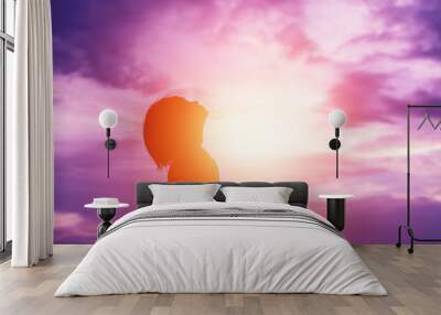 Silhouette of woman praying over beautiful sky background Wall mural