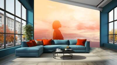 Silhouette of woman praying over beautiful sky background Wall mural