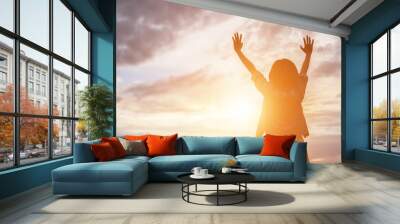 Silhouette of woman praying over beautiful sky background Wall mural