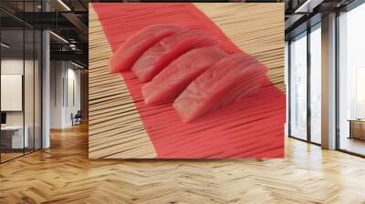 A close up of four pieces of pink meat on a red background Wall mural