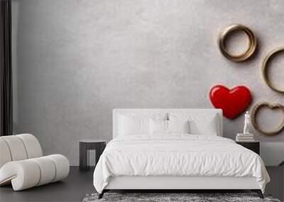 A romantic flat lay featuring an envelope, heart, and wedding rings. Wall mural