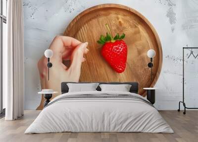 A single strawberry on a wooden plate. Wall mural