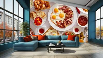 A table full of breakfast foods, including eggs, bacon, toast, and fruit. Wall mural