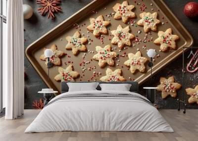 Freshly baked star-shaped sugar cookies on a baking sheet with sprinkles and holiday decor. Wall mural