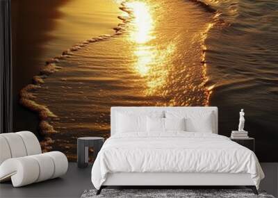 Golden sunlight reflecting on the water as a wave recedes on a sandy beach. Wall mural