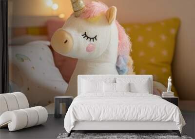 Plush unicorn toy on a bed with a pastel blue blanket. Wall mural