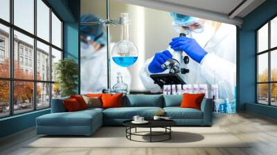 Scientist or researcher hand in blue gloves holding flu, measles, coronavirus, covid-19 vaccine disease preparing for human clinical trials vaccination shot, medicine and drug concept. Wall mural