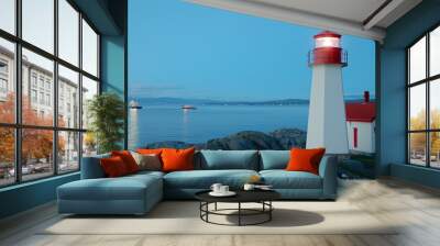 A serene twilight scene featuring two lighthouses by the rocky shoreline, illuminated against a calm sea, evoking a sense of solitude and tranquility. Wall mural