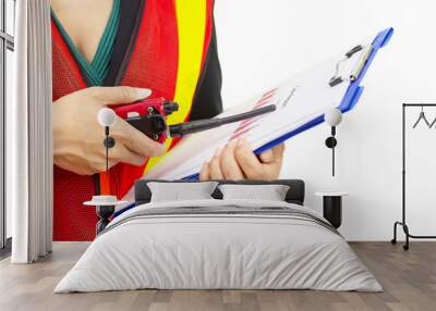 Young woman holding a document and using a radio to point to a report paper.  isolated indoors white background. Wall mural